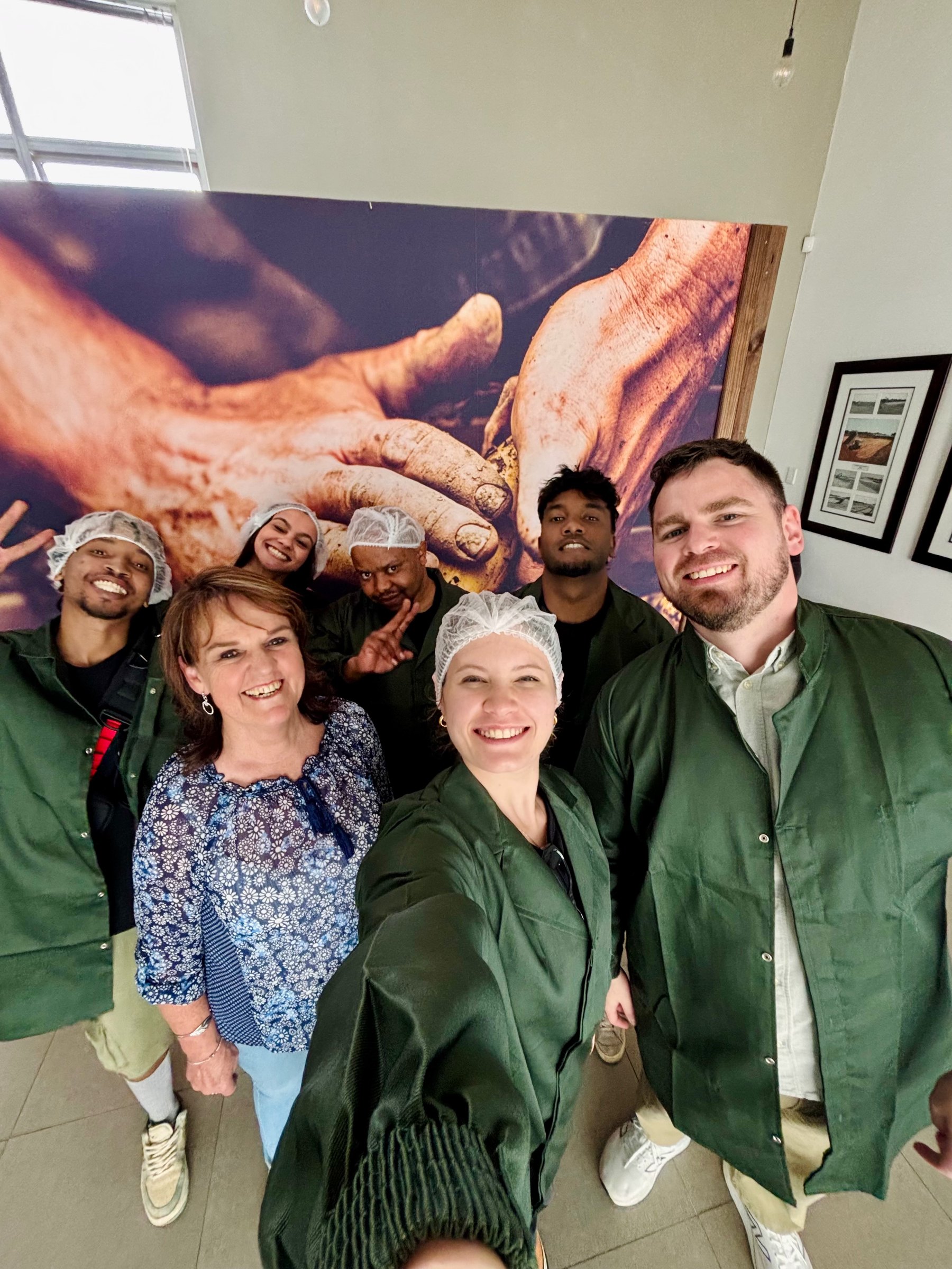 The crew together in hairnets and coveralls on a factory shoot