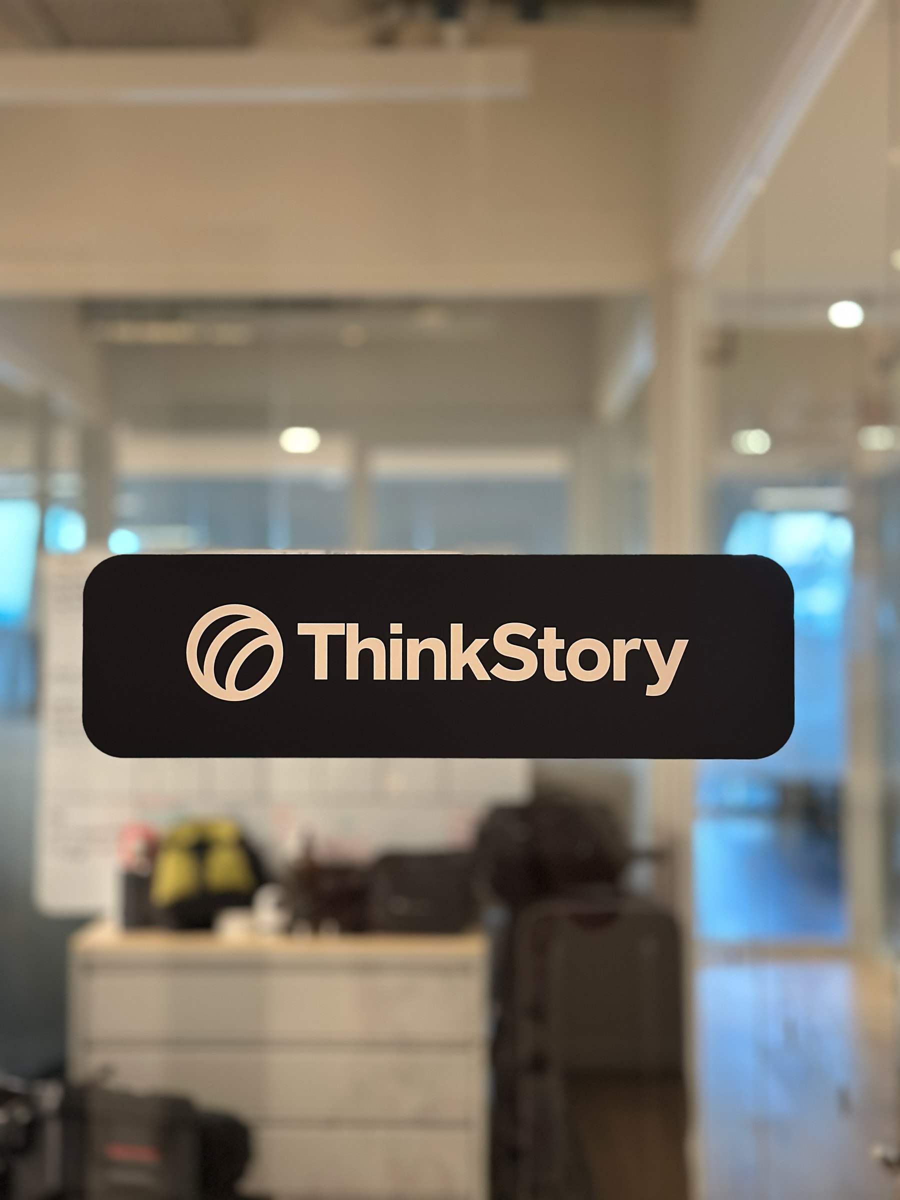The ThinkStory mark on the studio glass