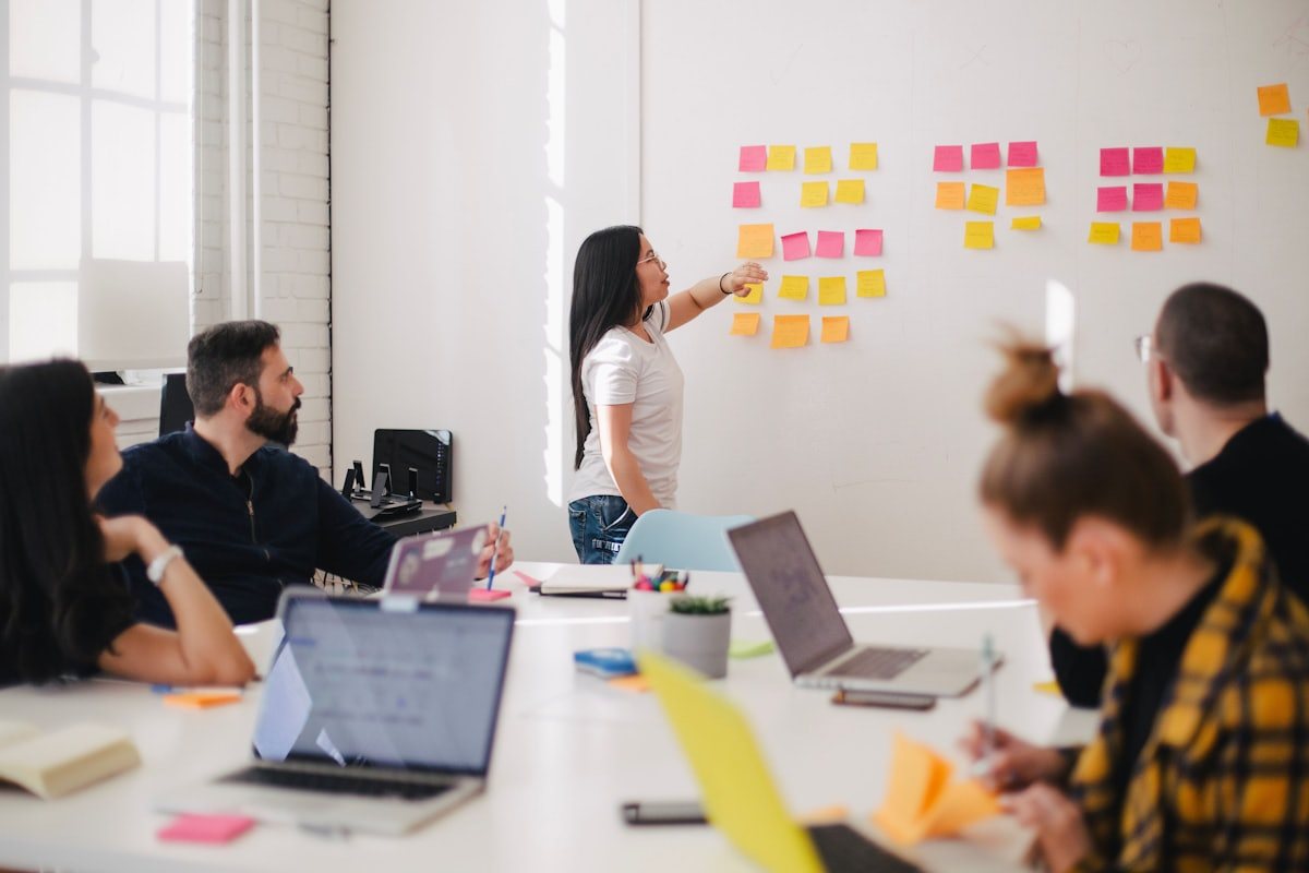 A team working through ideas on sticky notes at a whiteboard