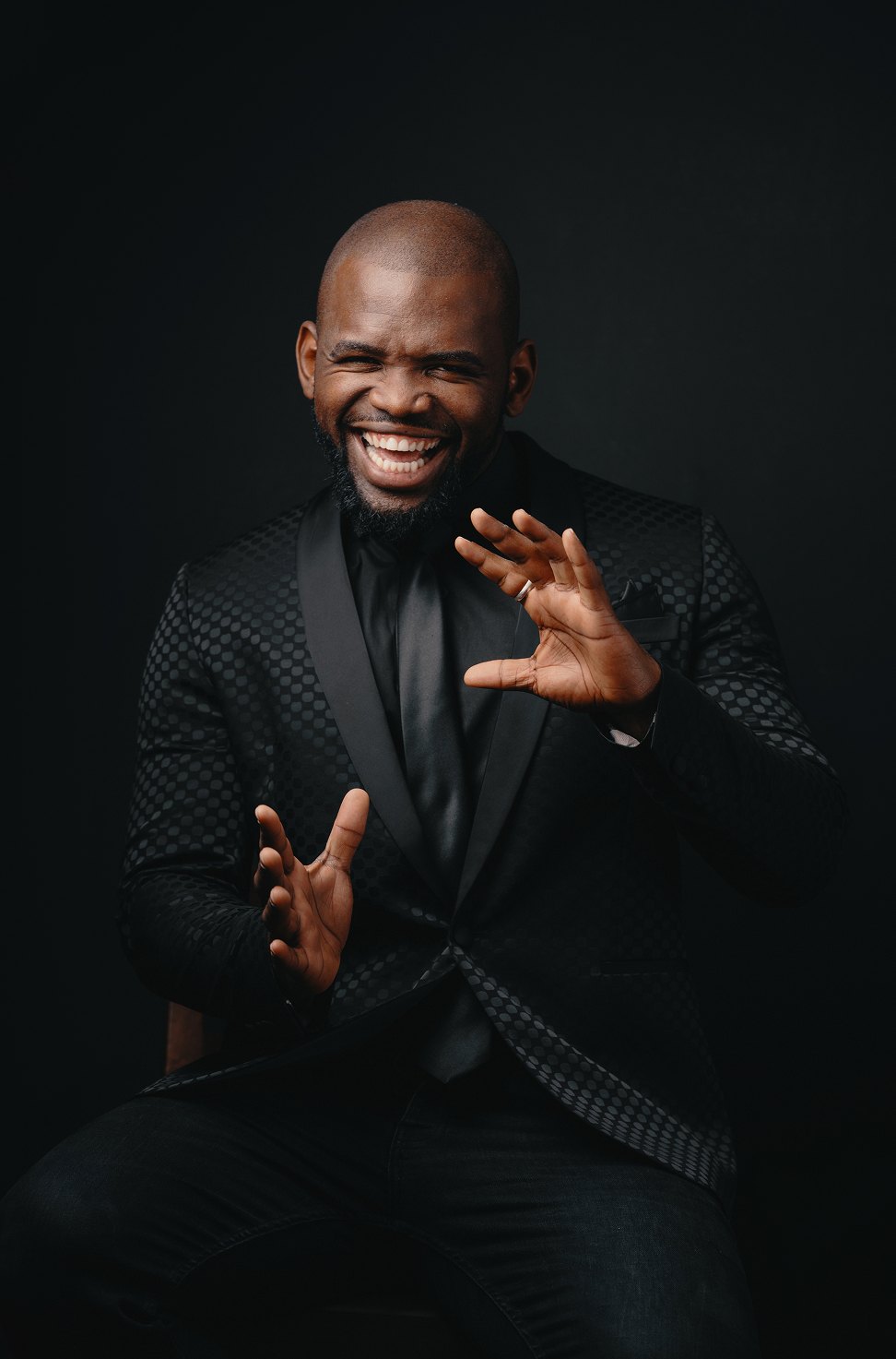 A studio portrait in a black suit